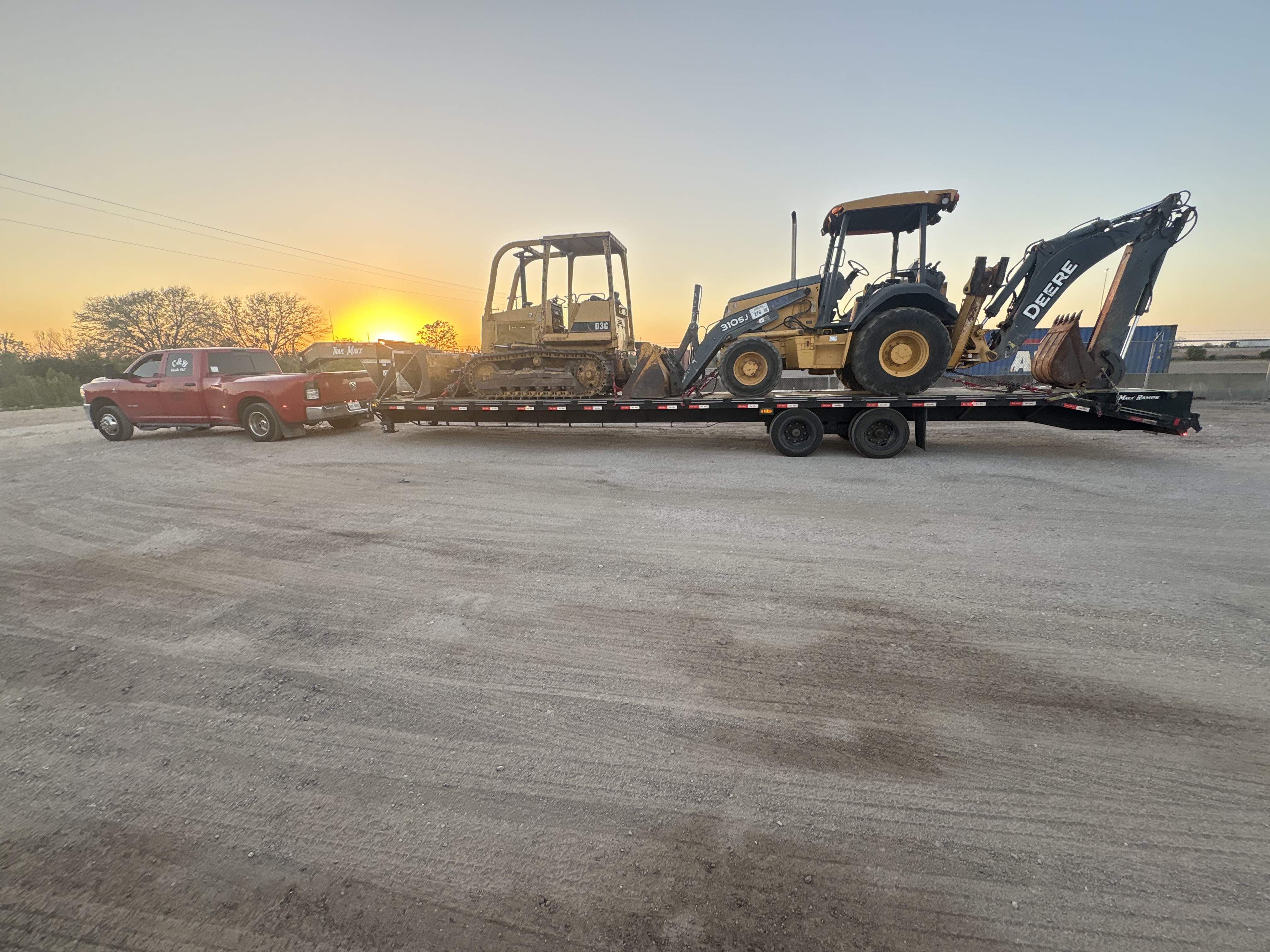 Bulldozer and Backhoe Haul at Sunset